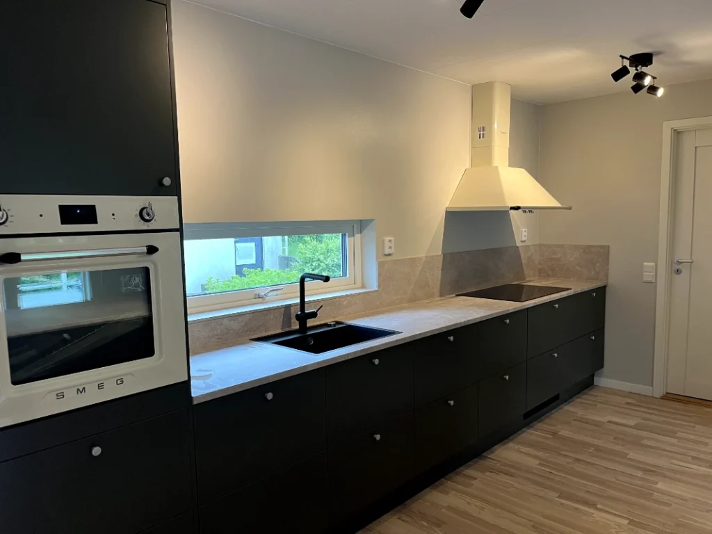 Byggarbetare som monterar stålbalkar på en modern byggarbetsplats under klarblå himmel. Säkerhetsutrustning synlig.