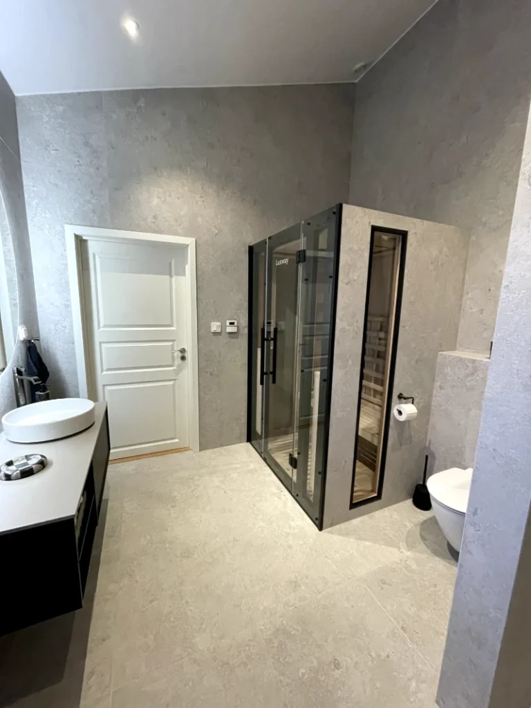 Arbetare installerar takpaneler på ett husbygge under en solig dag, med säkerhetsutrustning och verktyg i förgrunden.