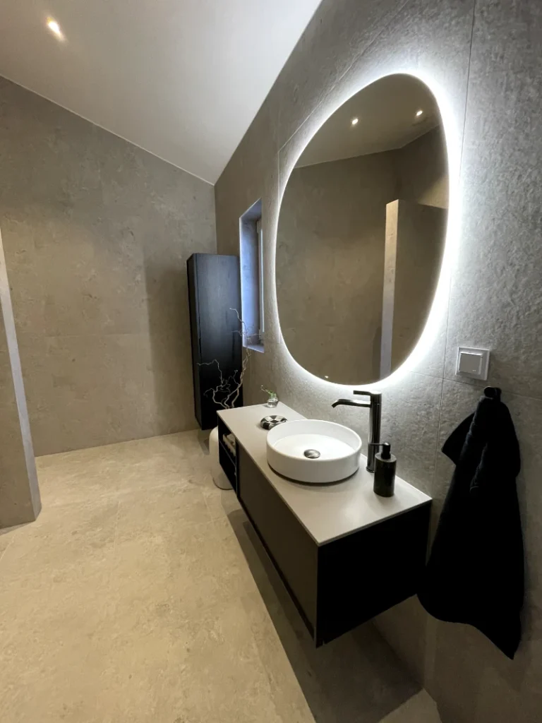 Snickare i Fristad mäter träplanka i verkstad, planerar skåpbyggnation. Fokus på precision och hantverkskvalitet.